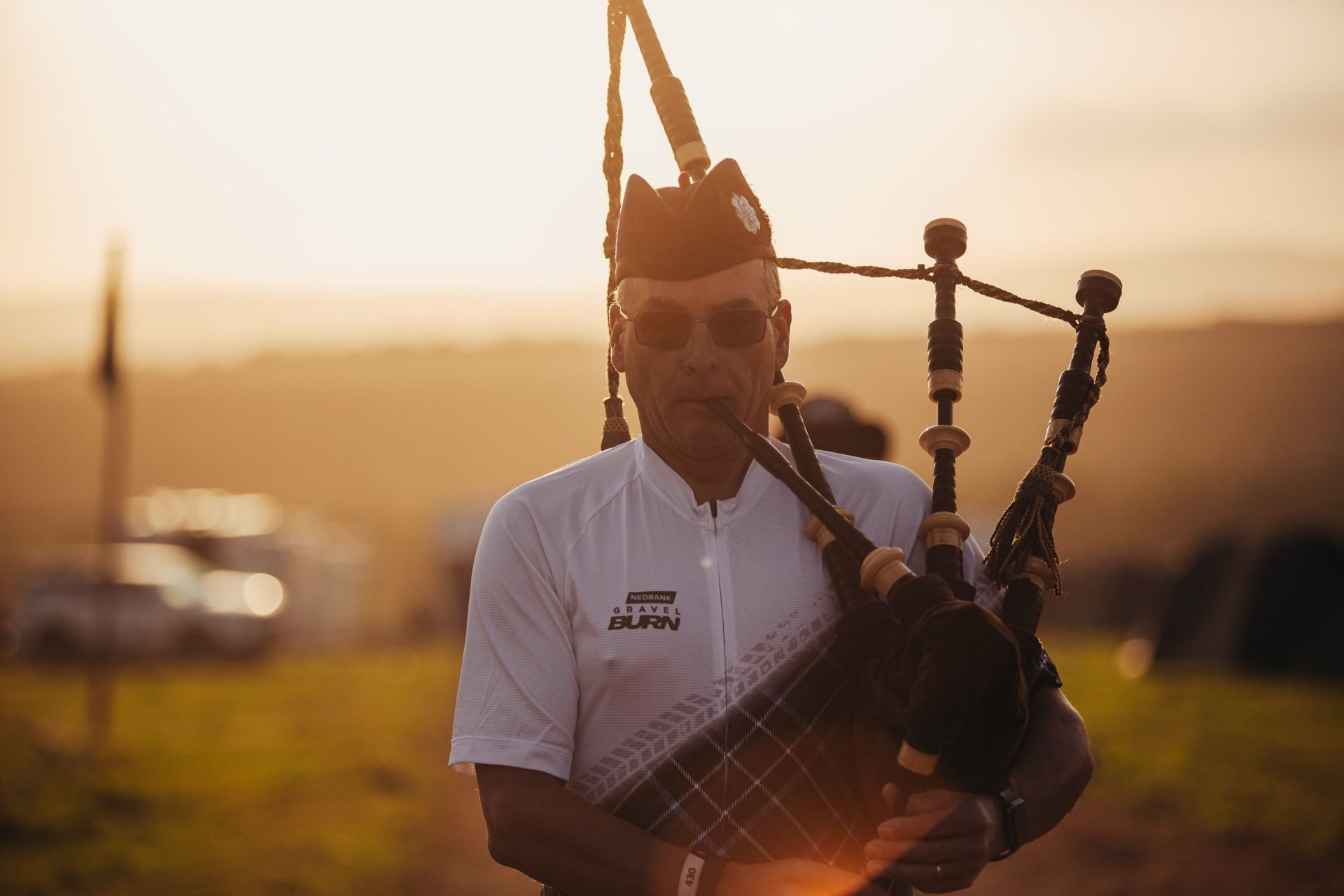 A bagpiper in a kilt playing at sunrise in the Burn Camp