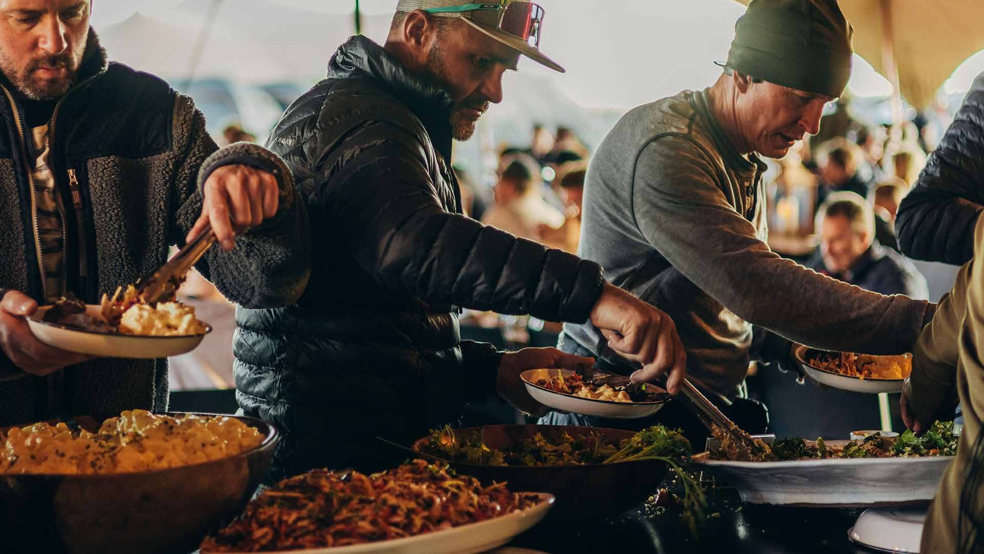 Riders serving themselves from the buffet in camp