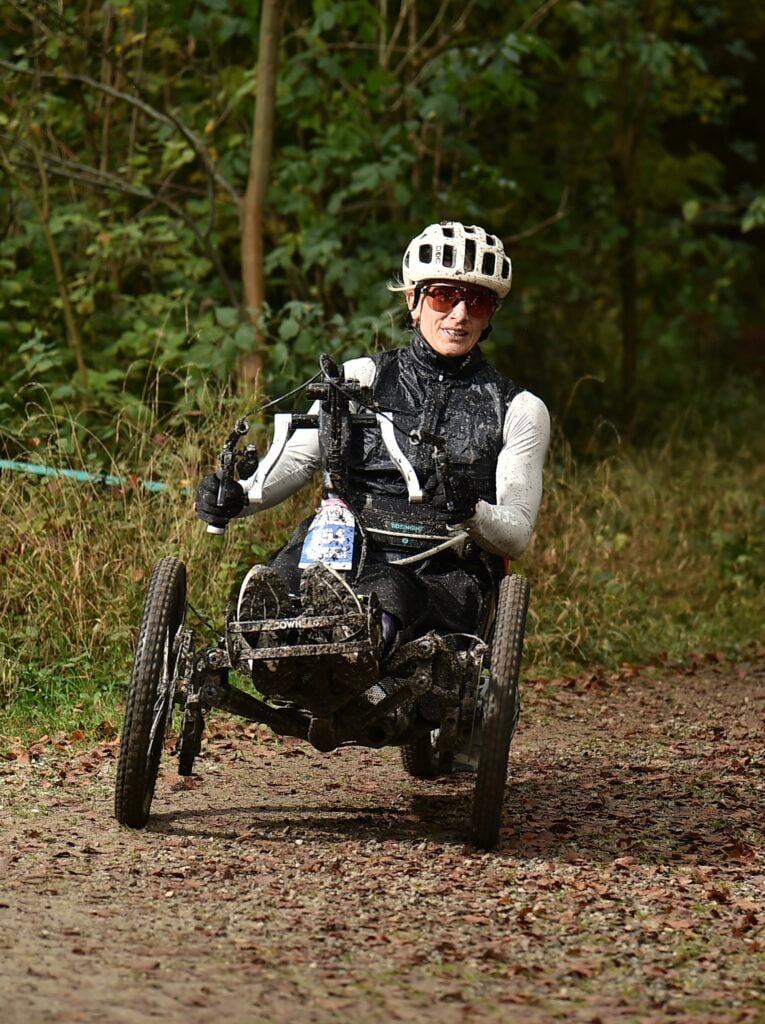 An adaptive rider on a Bowhead on a forest trail